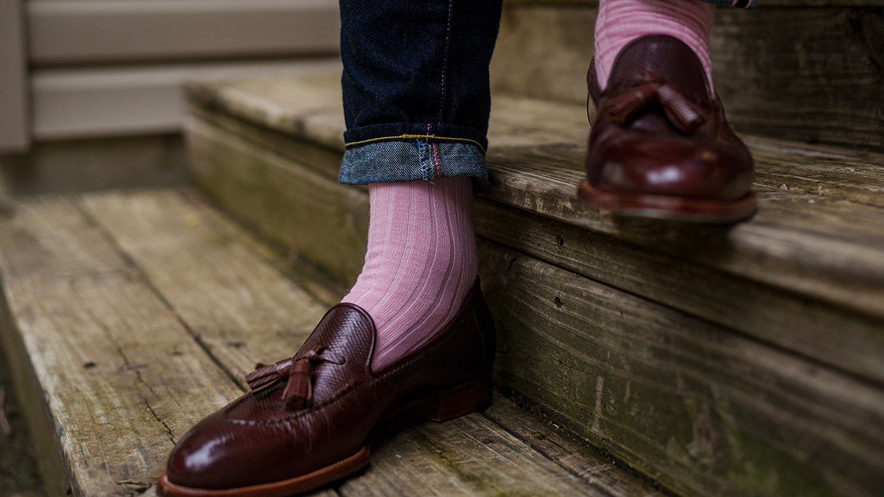 pastel pink dress socks worn with dark denim and brown tassel loafers