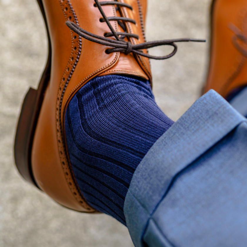 navy dress socks for men paired with light brown dress shoes and blue dress pants