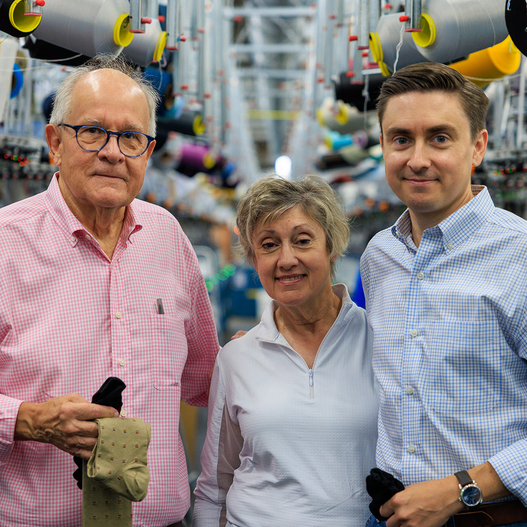 James family of Boardroom Socks smiling and standing in knitting mill