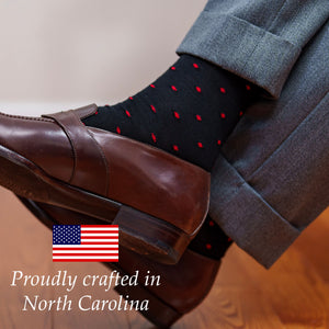man crossing ankles wearing black and red dress socks made in the usa