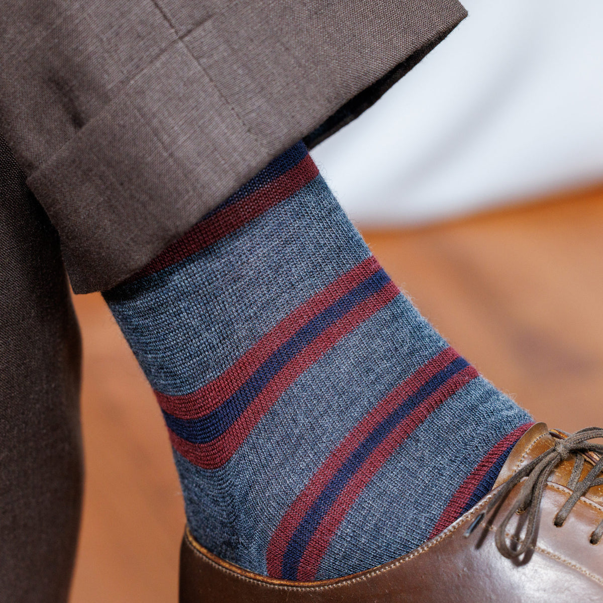 close up image of Burgundy and Navy Stripes on Grey Merino Wool Over the Calf Dress Socks worn with brown shoes and pants