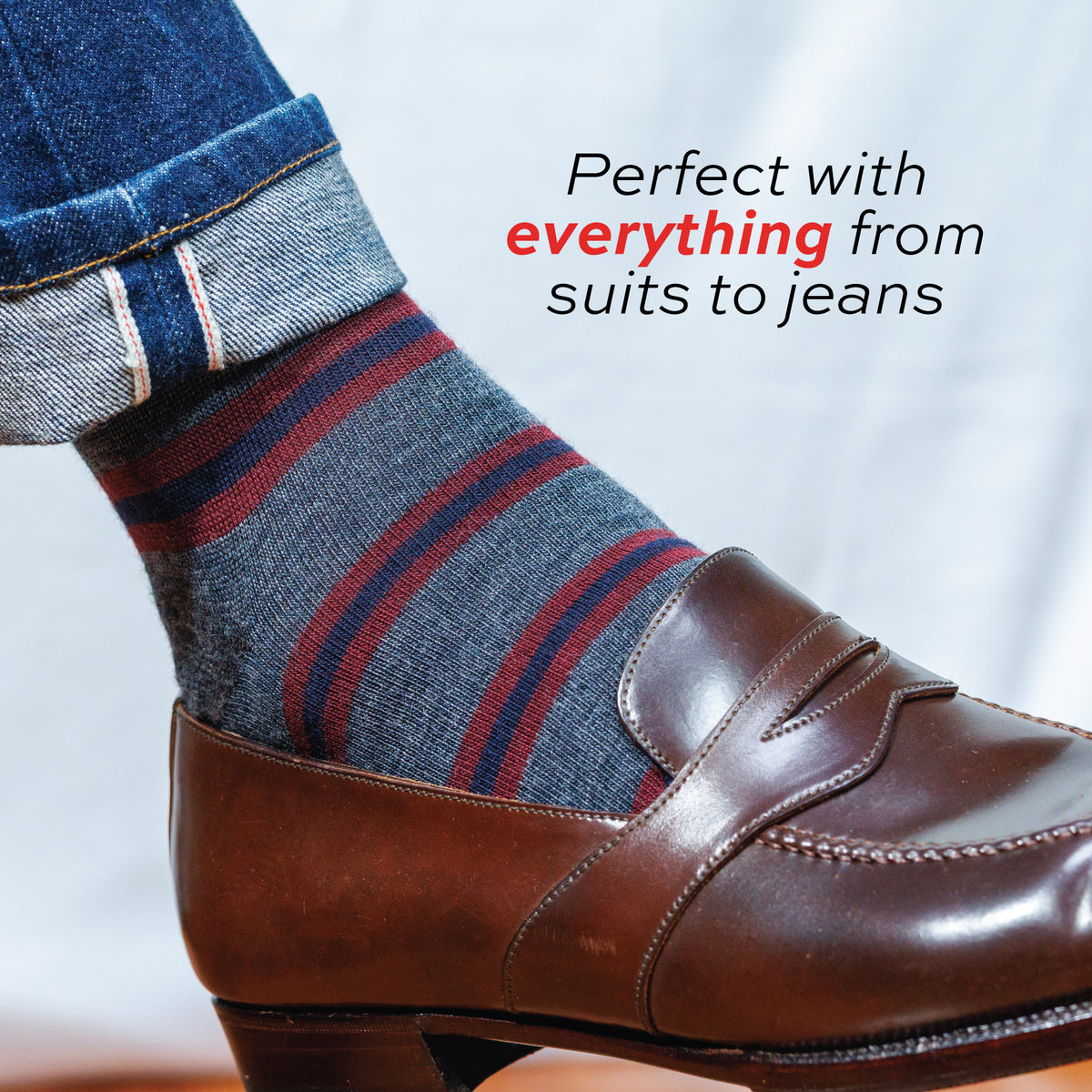 close up image of a man wearing jeans, nice shoes and Burgundy and Navy Stripes on Grey Merino Wool Over the Calf Dress Socks with text overlay