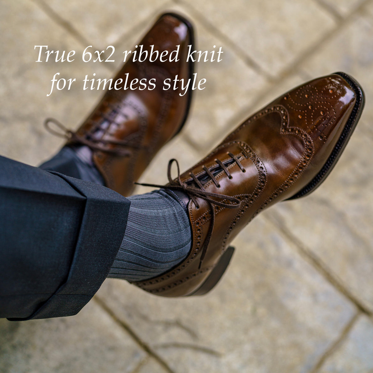 man crossing legs showing grey ribbed cotton dress socks and dark brown wingtip dress shoes