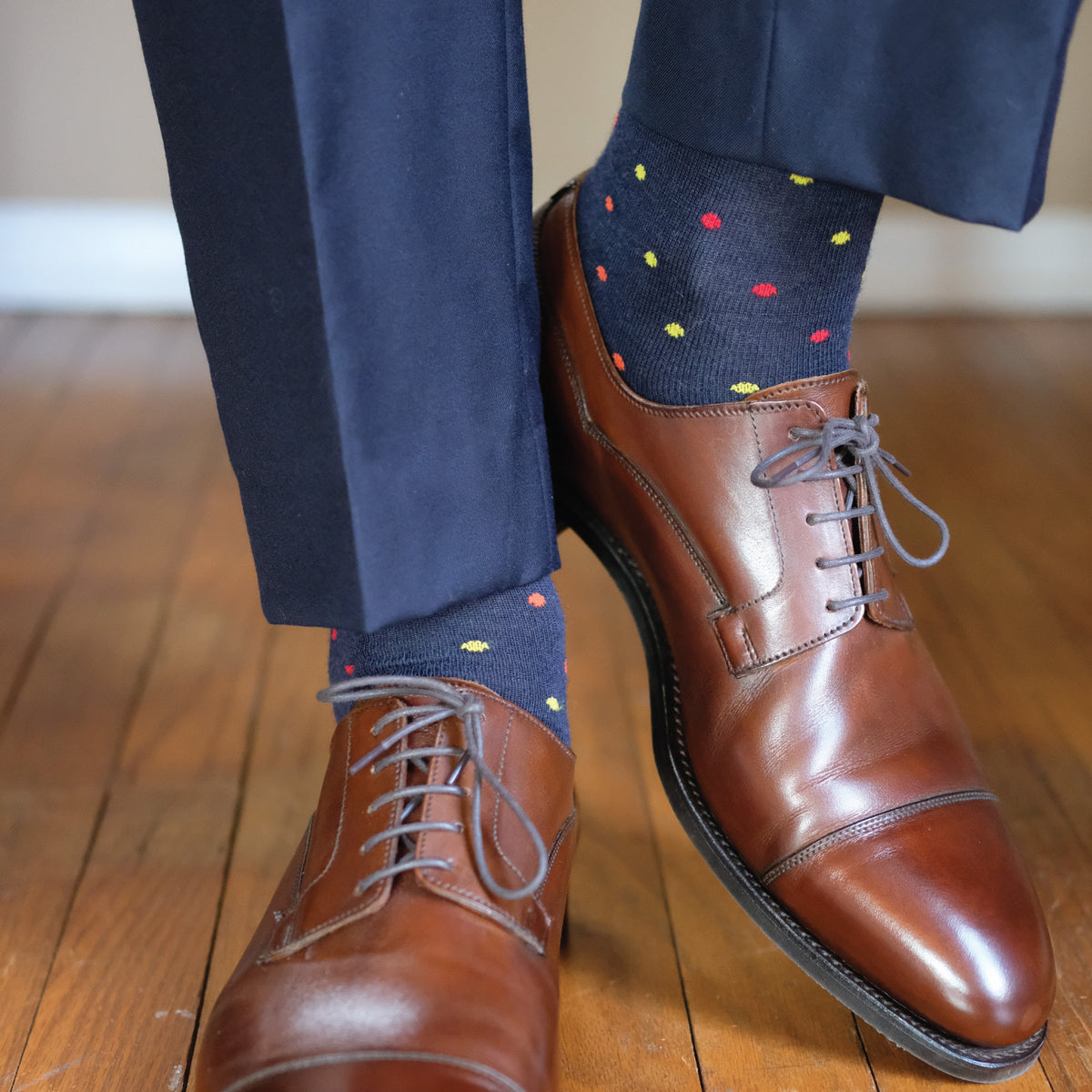 well dressed man standing on hardwood floors wearing patterned dot merino wool mens dress socks