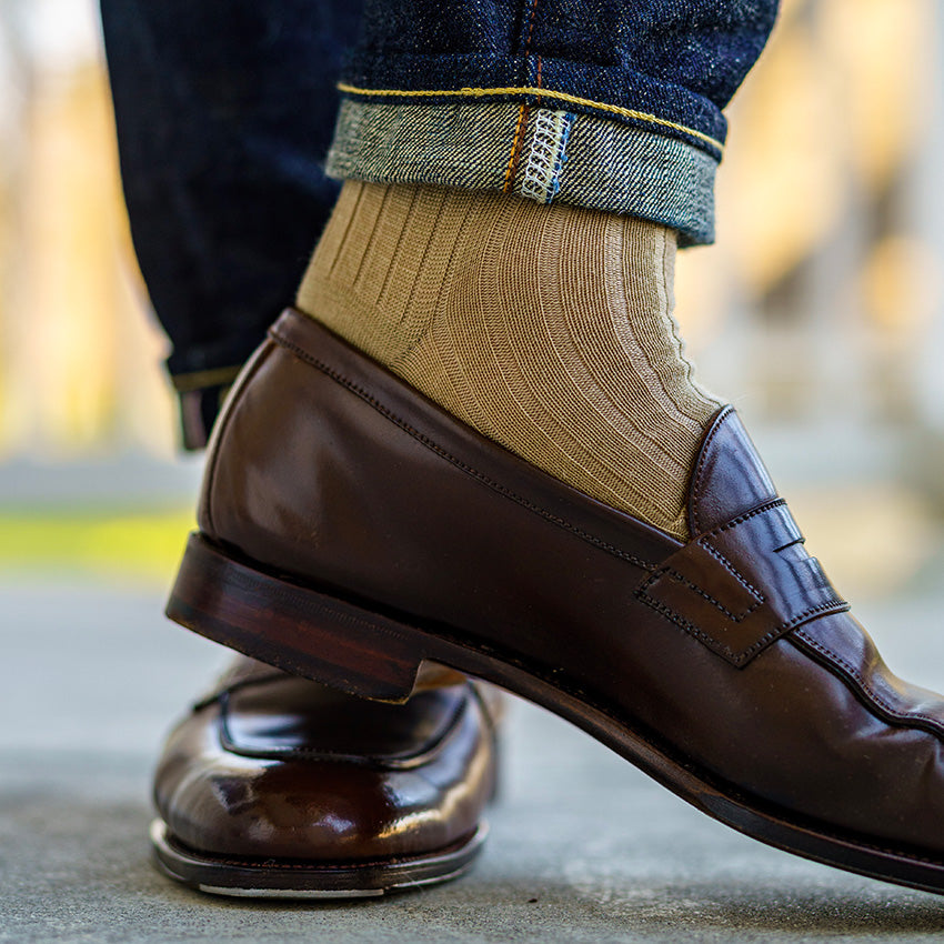 men's khaki dress socks paired with jeans and brown penny loafers