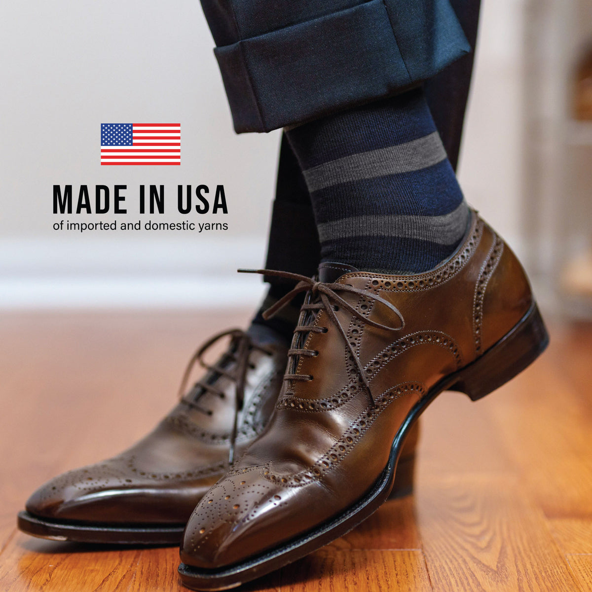 man crossing feet wearing Grey Heather Stripes on Navy Merino Wool Mid-Calf Dress Socks