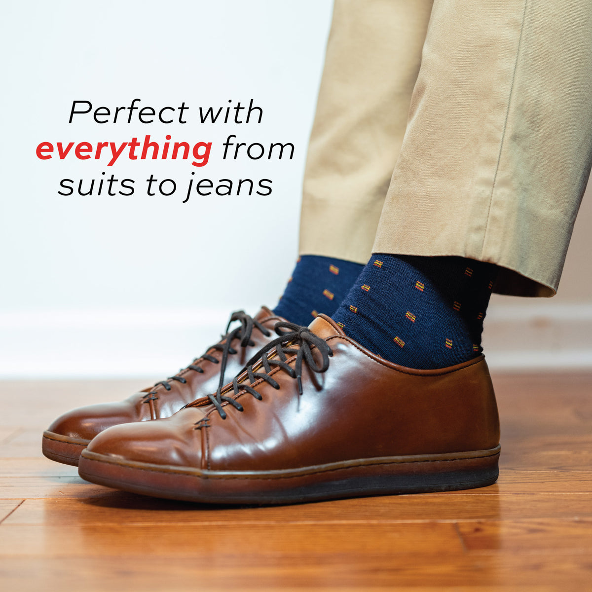 man standing on a hardwood floor wearing khaki pants, casual brown shoes and Orange Square Knots on Navy Merino Wool Mid Calf Dress Socks