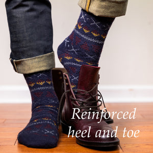 man wearing navy Fair Isle merino wool socks stepping into pair of dress boots