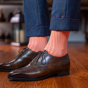 peach dress socks with brown wingtips and a navy windowpane suit