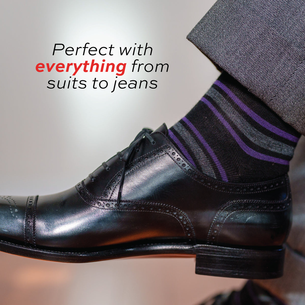 close up image of a mans foot wearing Purple and Grey Stripes on Black Merino Wool Over the Calf Dress Socks and black dress shoes