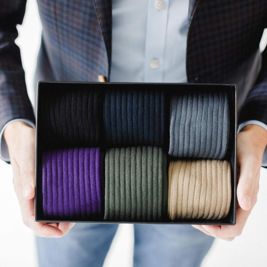 Man Holding Small Black Gift Box Filled with Colorful Men's Dress Socks