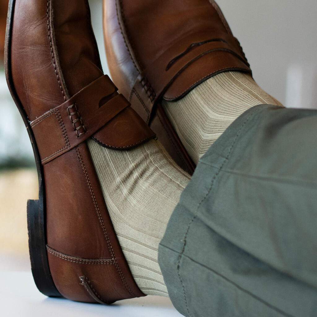 Man Crossing Ankles Wearing Khaki Dress Socks with Olive Pants and Brown Penny Loafers