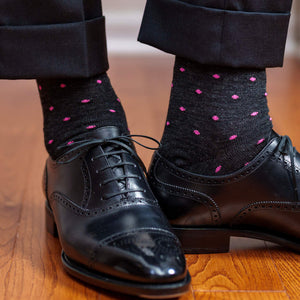 man wearing charcoal grey dress socks decorated with pink dots