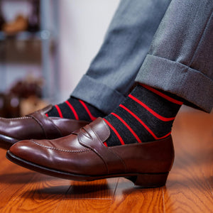 dark grey and bright red striped dress socks with light grey trousers and brown penny loafers