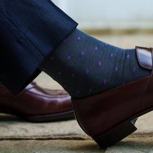 grey dress socks with purple dots paired with navy trousers and dark brown penny loafers