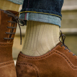 man walking wearing khaki cotton dress socks and jeans with light brown suede dress shoes