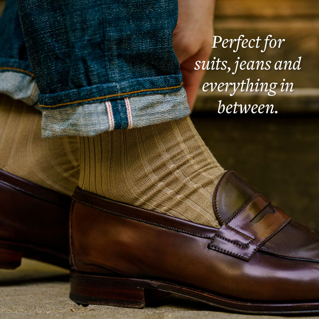man wearing khaki dress socks with dark jeans and brown penny loafers
