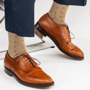 khaki patterned dress socks paired with navy pants and light brown dress shoes