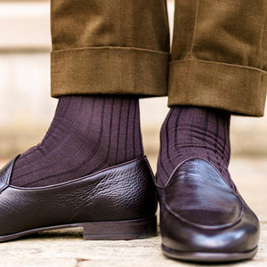 man standing wearing brown ribbed dress socks and dark brown loafers