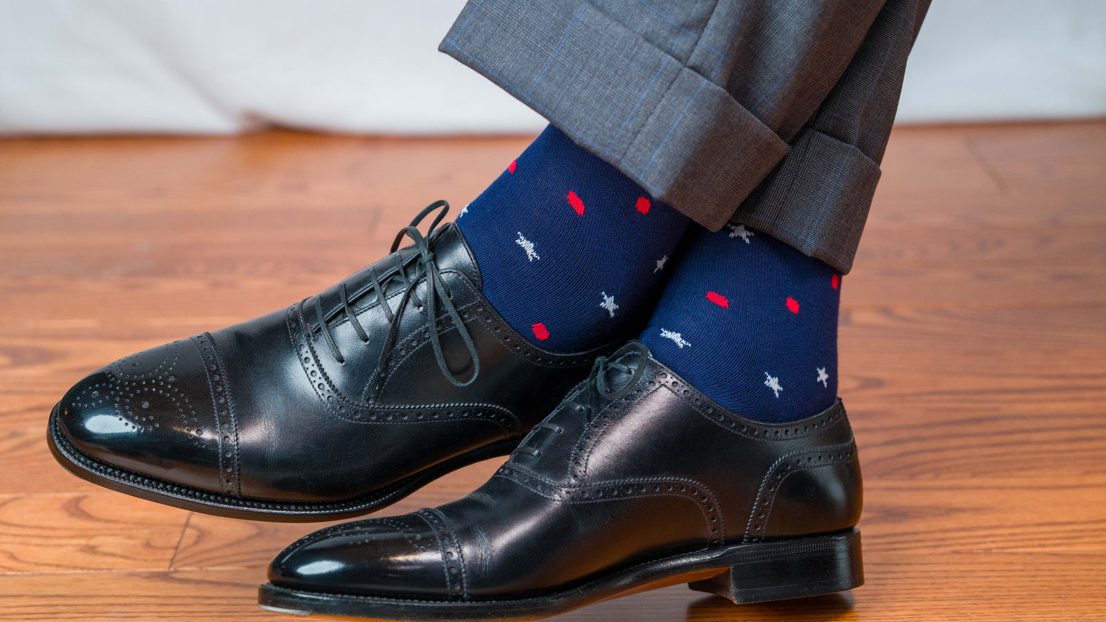 Man wearing navy stars and dots Americana cotton dress socks with nice shoes
