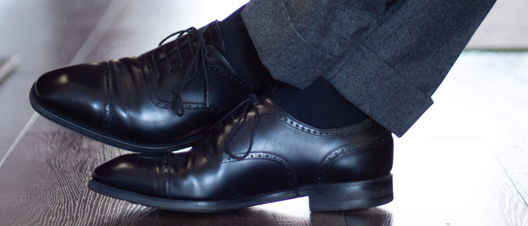 black cap toe oxford dress shoes with navy dress socks and dark grey trousers