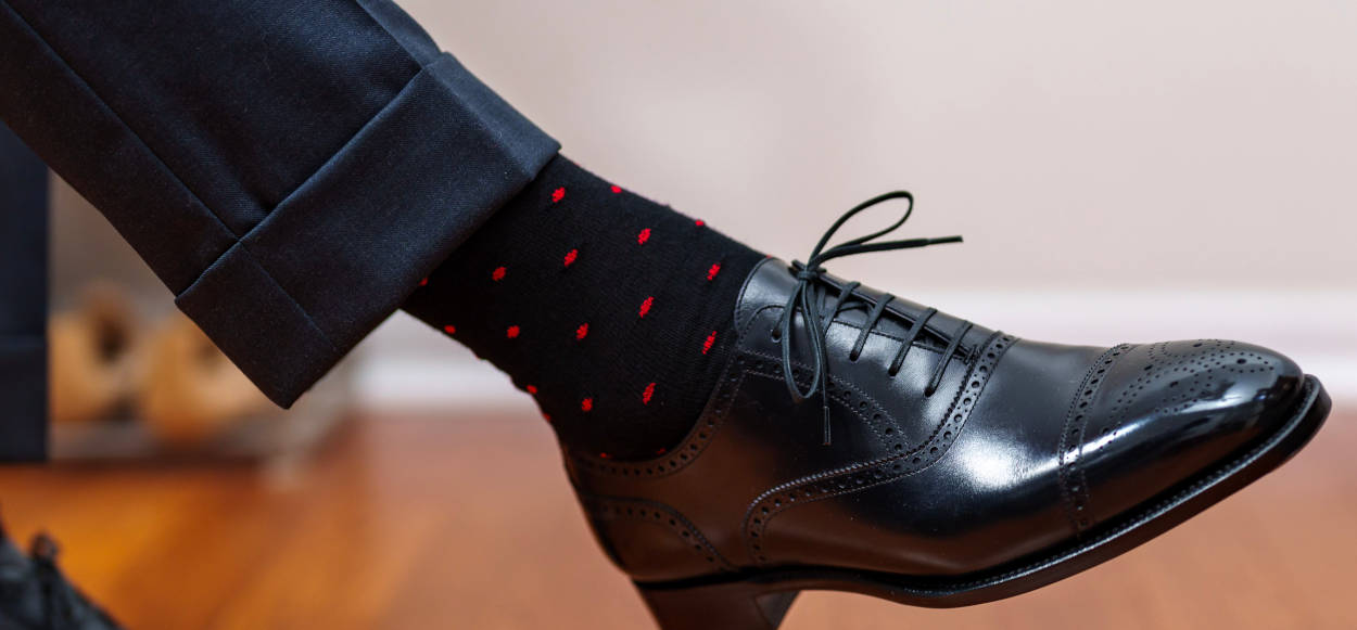 black dress socks with red polka dots and a charcoal suit