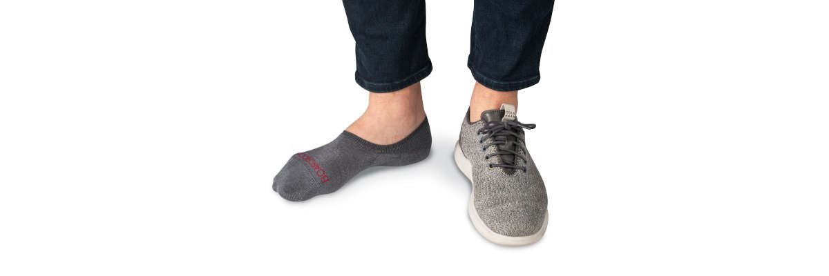 man wearing grey no show dress socks with dress sneakers and jeans