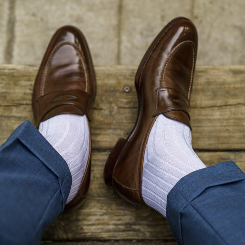 man wearing white dress socks with blue dress pants and brown penny loafers
