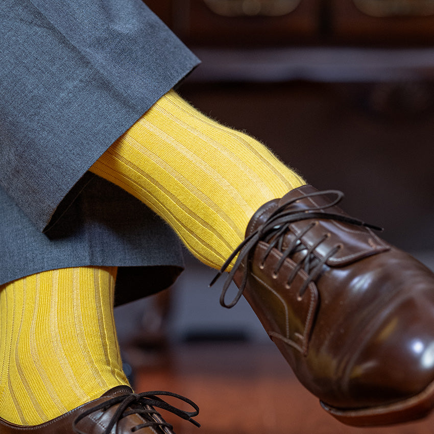 yellow dress socks paired with a grey suit and dark brown dress shoes