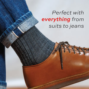 close up of a man wearing jeans and grey heather merino wool dress socks with prefect with everything text overlay
