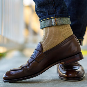 close up image of khaki merino wool ribbed dress socks worn with jeans and brown loafers