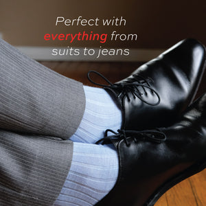 man crossing his legs wearing nice pants, black shoes and sky blue merino wool dress socks