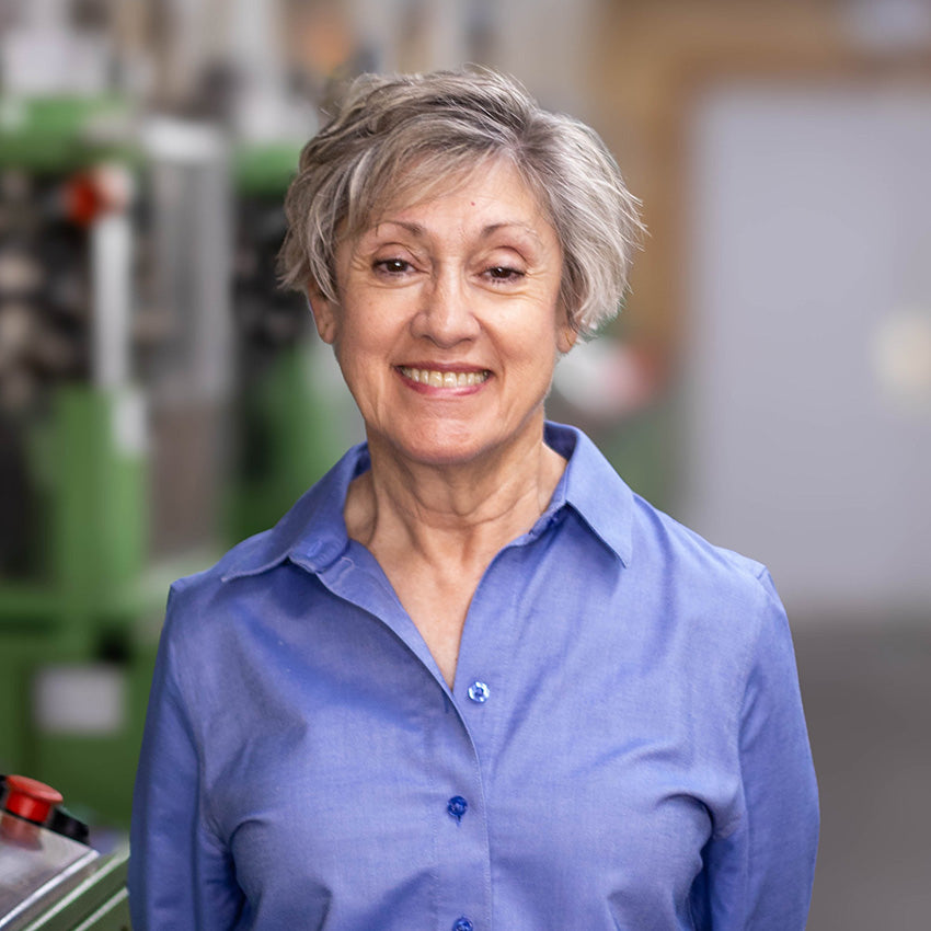 Headshot of Carol James, co-founder of Boardroom Socks, standing in knitting mill.