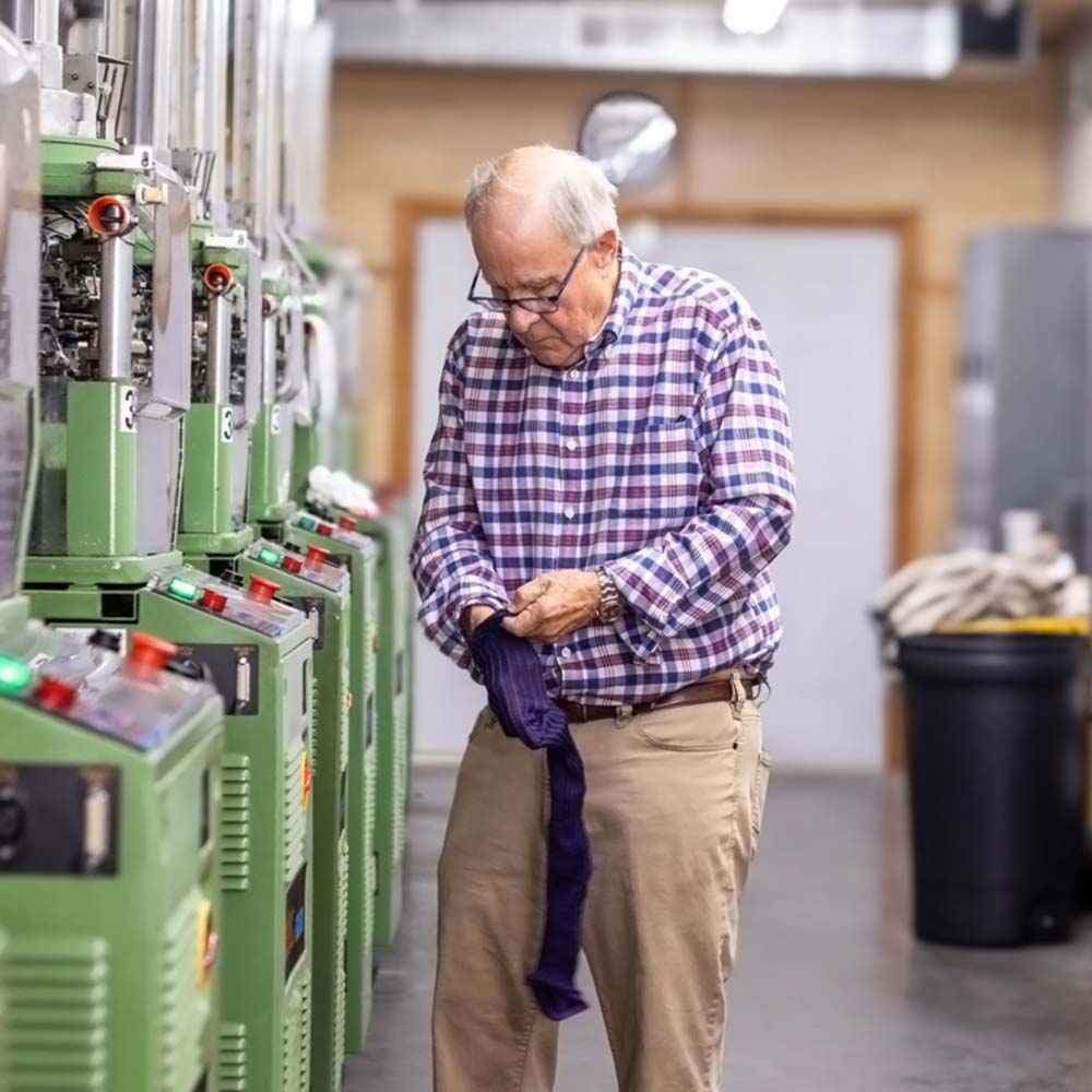 Mike James from Boardroom Socks working in hosiery mill examining socks.