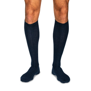 model wearing navy wool over the calf mens ribbed dress socks on a white background