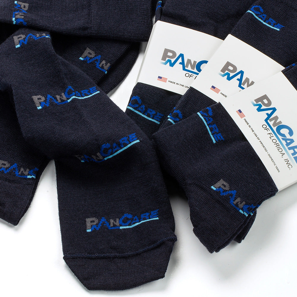 A pile of dark navy dress socks with the brand name 'PAN CARE' stitched in blue and gray, with branded packaging bands, on a white background.