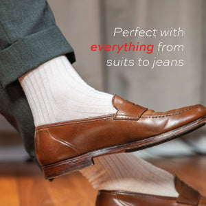 natural merino wool mid-calf dress socks worn on man crossing his legs with text overlay
