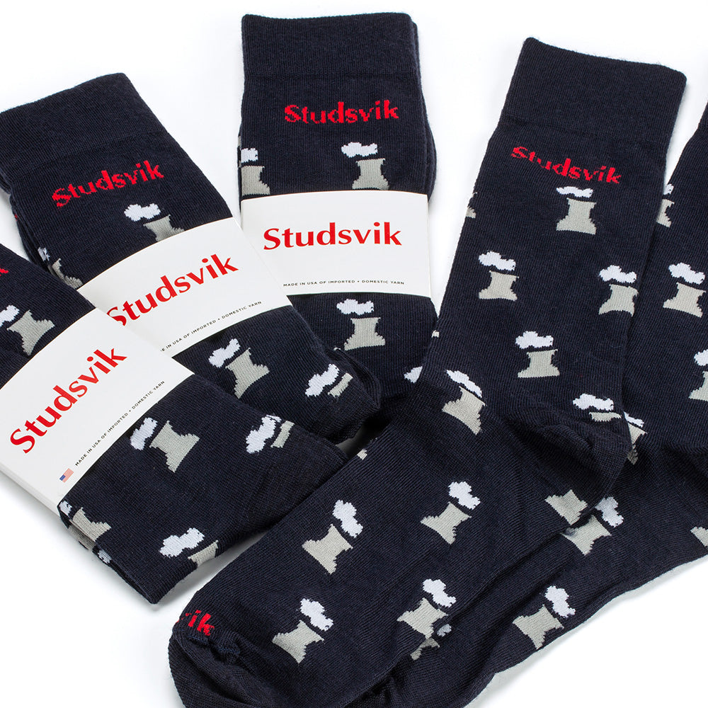 Four pairs of dark navy socks with a repeating pattern of small white and gray smoking nuclear cooling towers, each wrapped with a white paper band printed with the red Studsvik brand name.