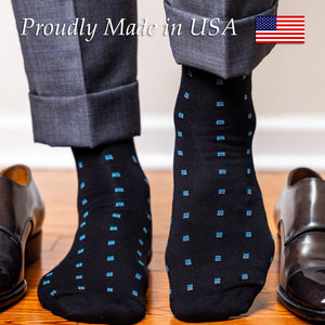 man walking on hardwood floors wearing black and blue patterned dress socks with a grey suit and black monkstrap shoes