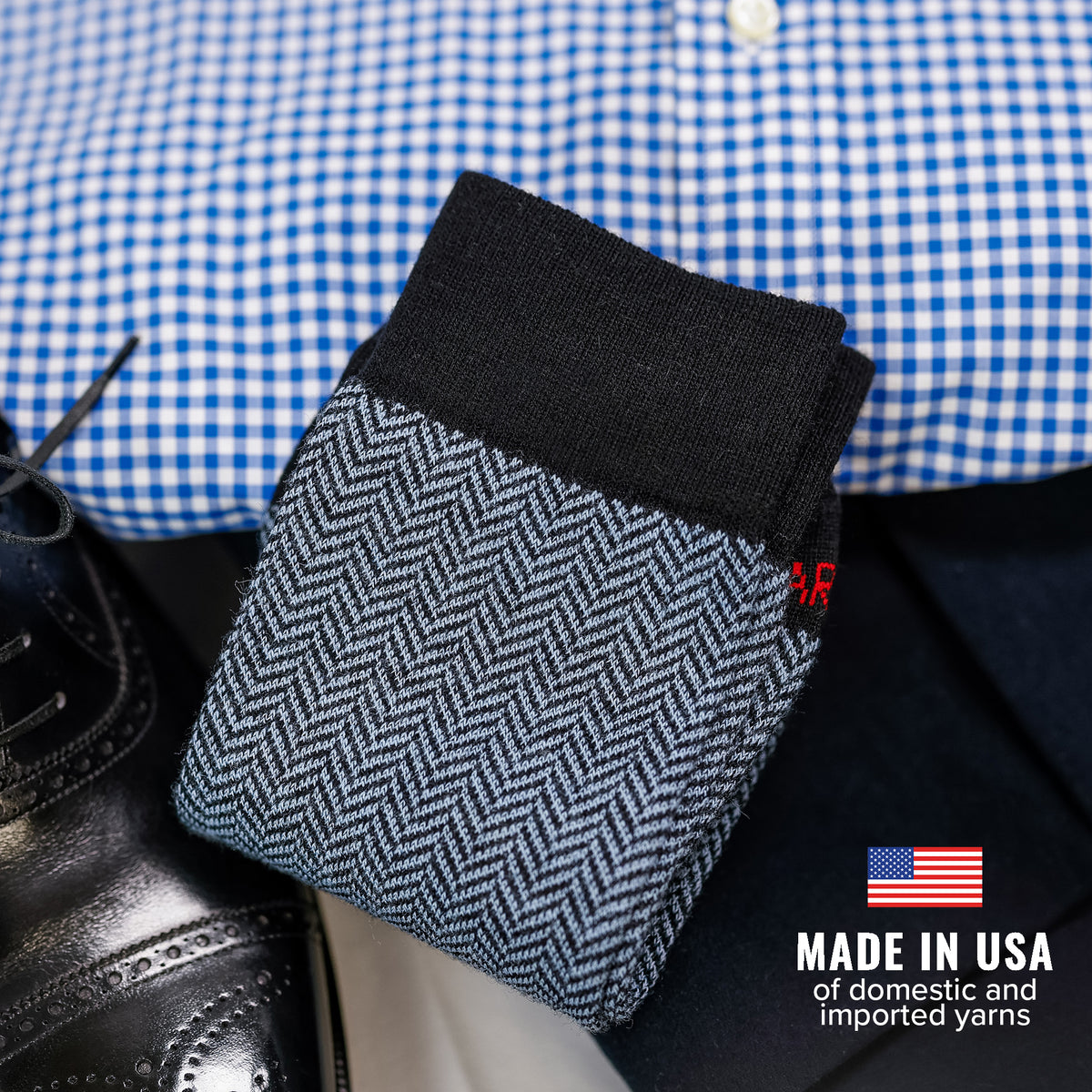black and light blue herringbone dress socks atop pair of business casual attire