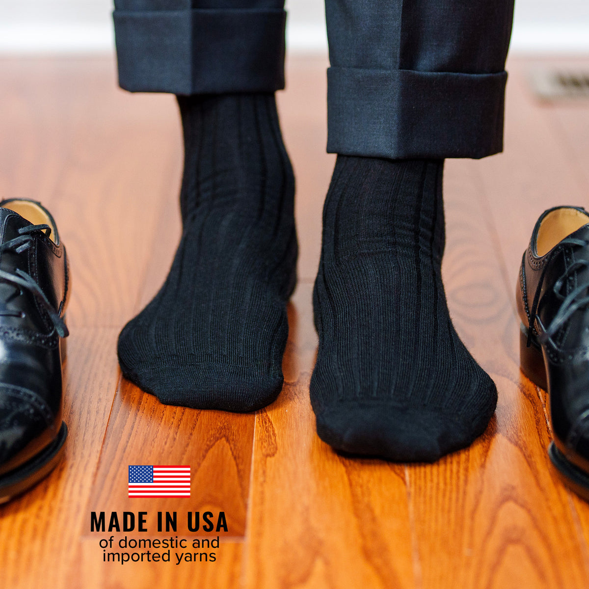 man wearing black merino wool dress socks from Boardroom Socks paired with black oxfords and dark grey suit