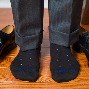 man standing on a hardwood floor wearing boardroom socks geometric pattern cotton dress socks