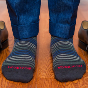 striped dress socks with 'BOARDROOM' branding worn on a wooden floor
