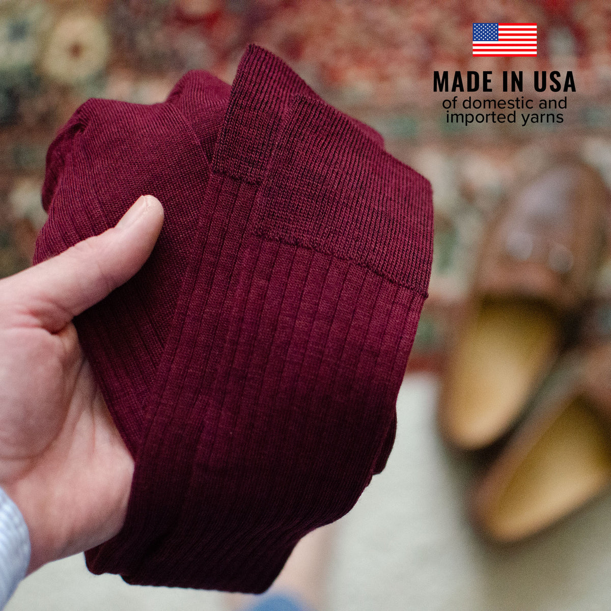 man holding pair of burgundy merino wool dress socks from Boardroom Socks