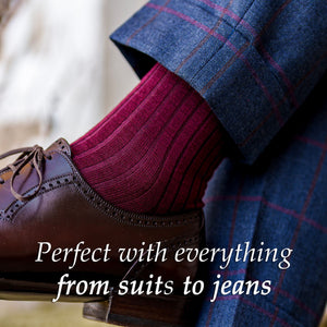 man wearing burgundy wool dress socks and plaid suit crossing legs