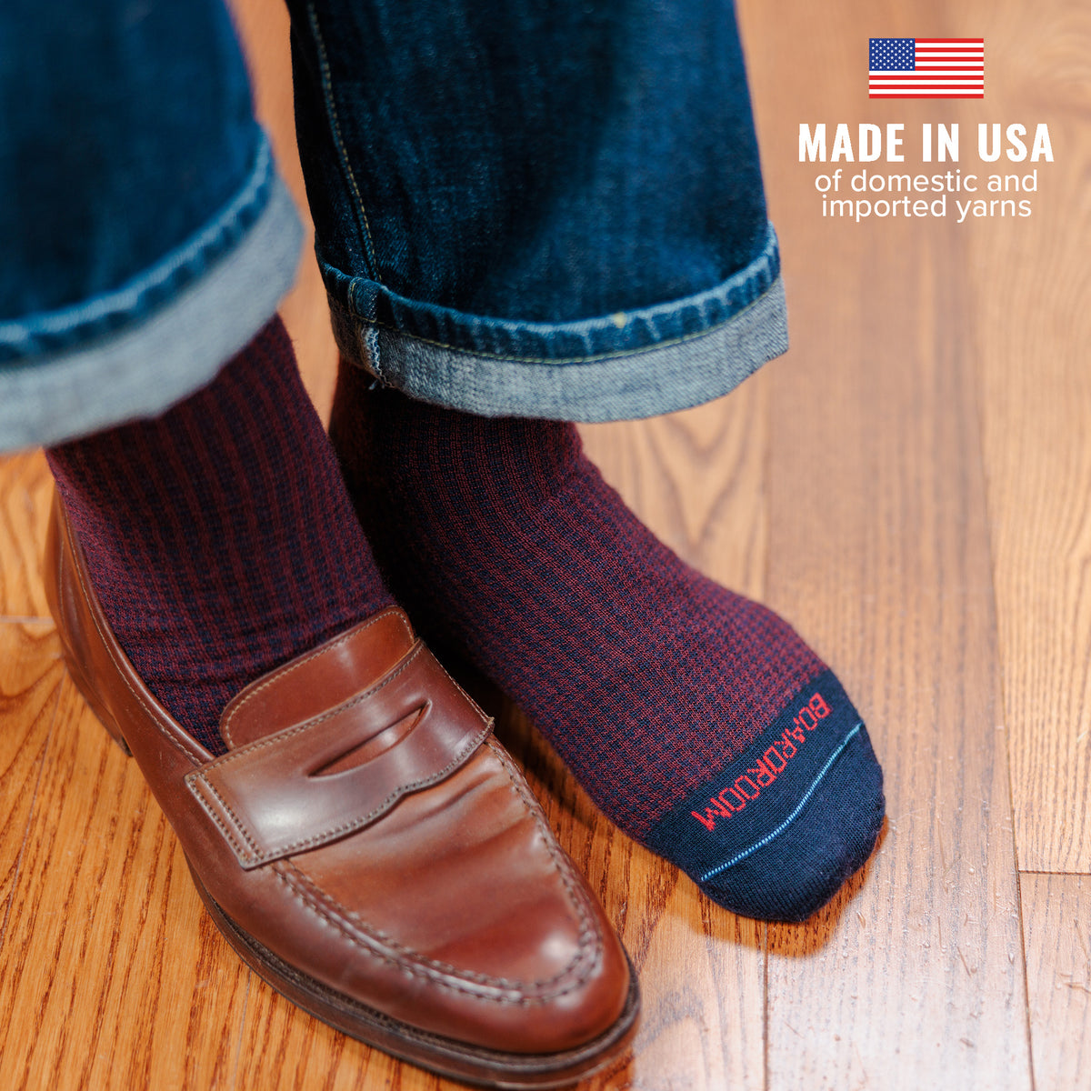man wearing burgundy and navy houndstooth dress socks with jeans and penny loafers