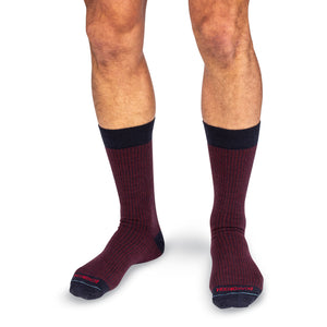 model wearing pair of mid-calf length burgundy and navy houndstooth dress socks