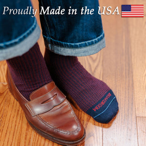 man wearing burgundy and navy houndstooth dress socks with jeans and brown penny loafers