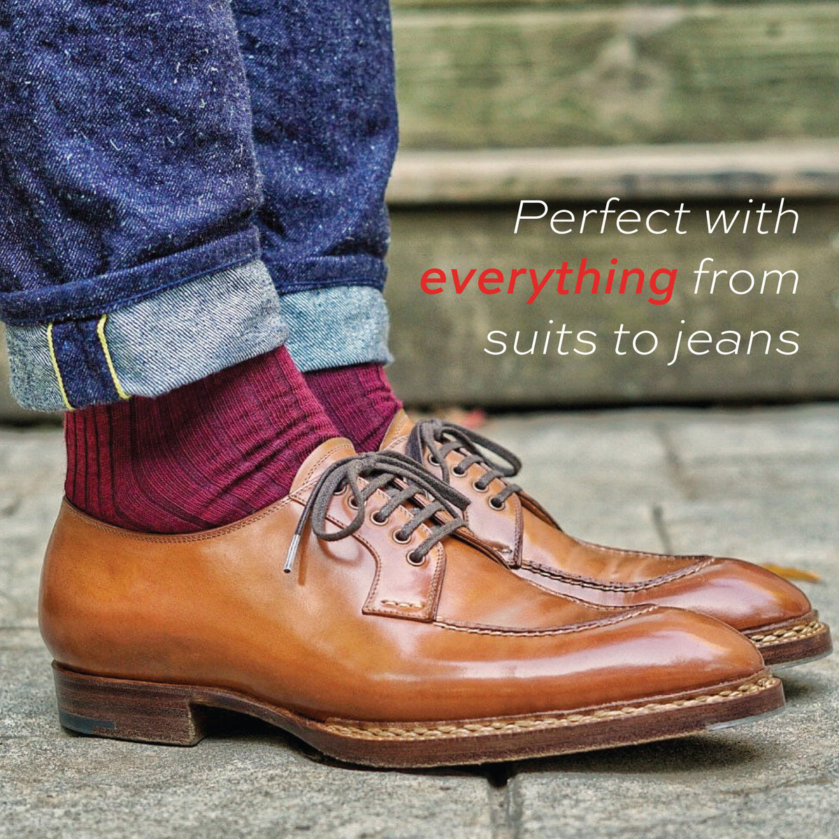 man standing wearing cuffed jeans and burgundy merino wool mid-calf dress socks 