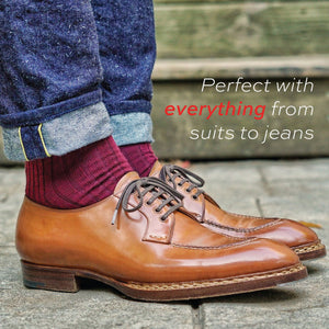 man standing wearing cuffed jeans and burgundy merino wool mid-calf dress socks 